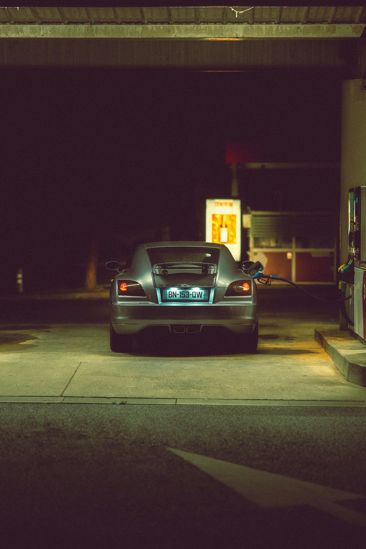 A car parked at a gas station at night